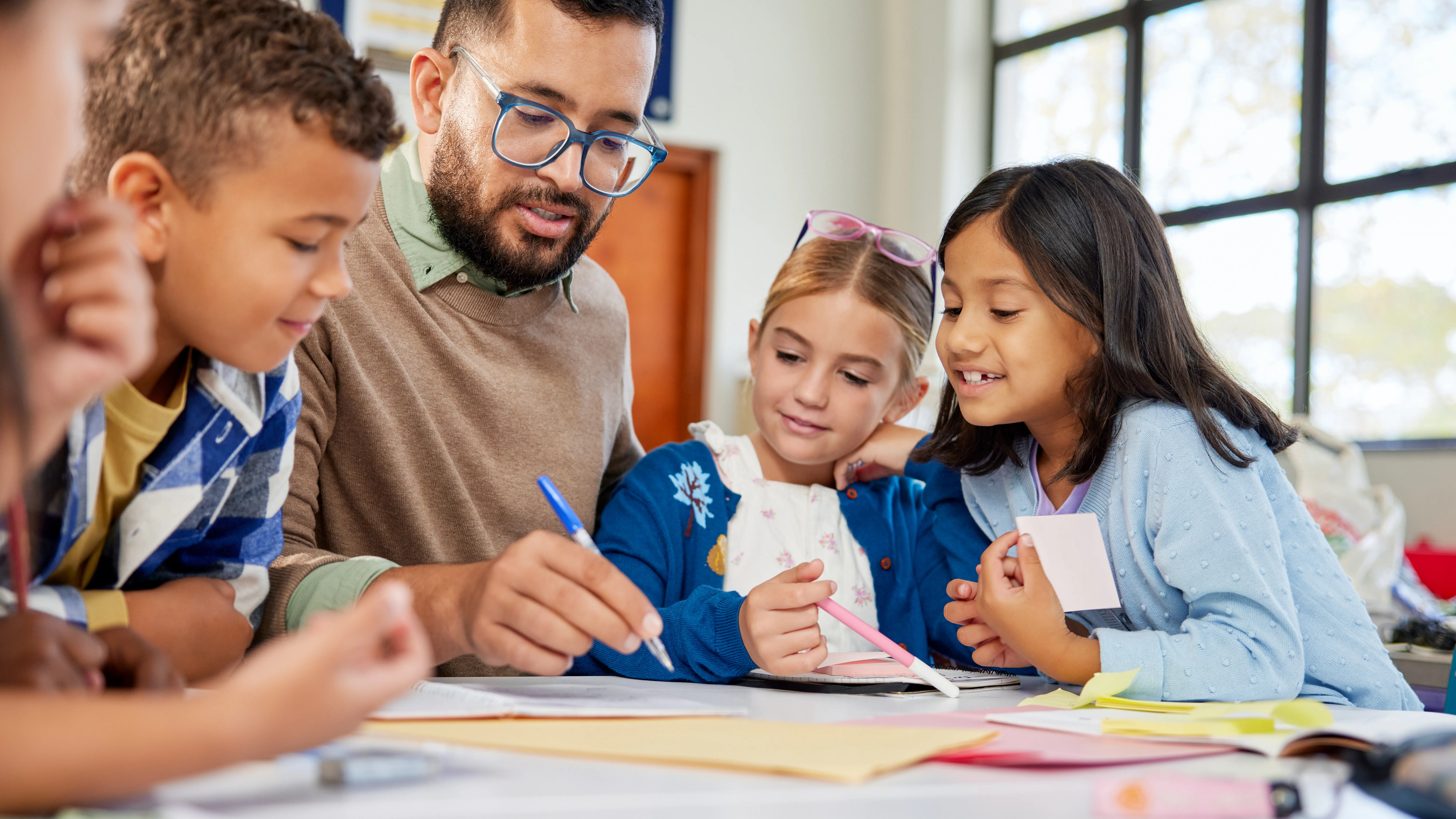 Teacher interacting with students at desks